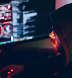 Man portraying Insider Threat and stealing data while viewing data on computer screen